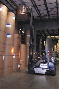 worker using fork lift to stack cartons