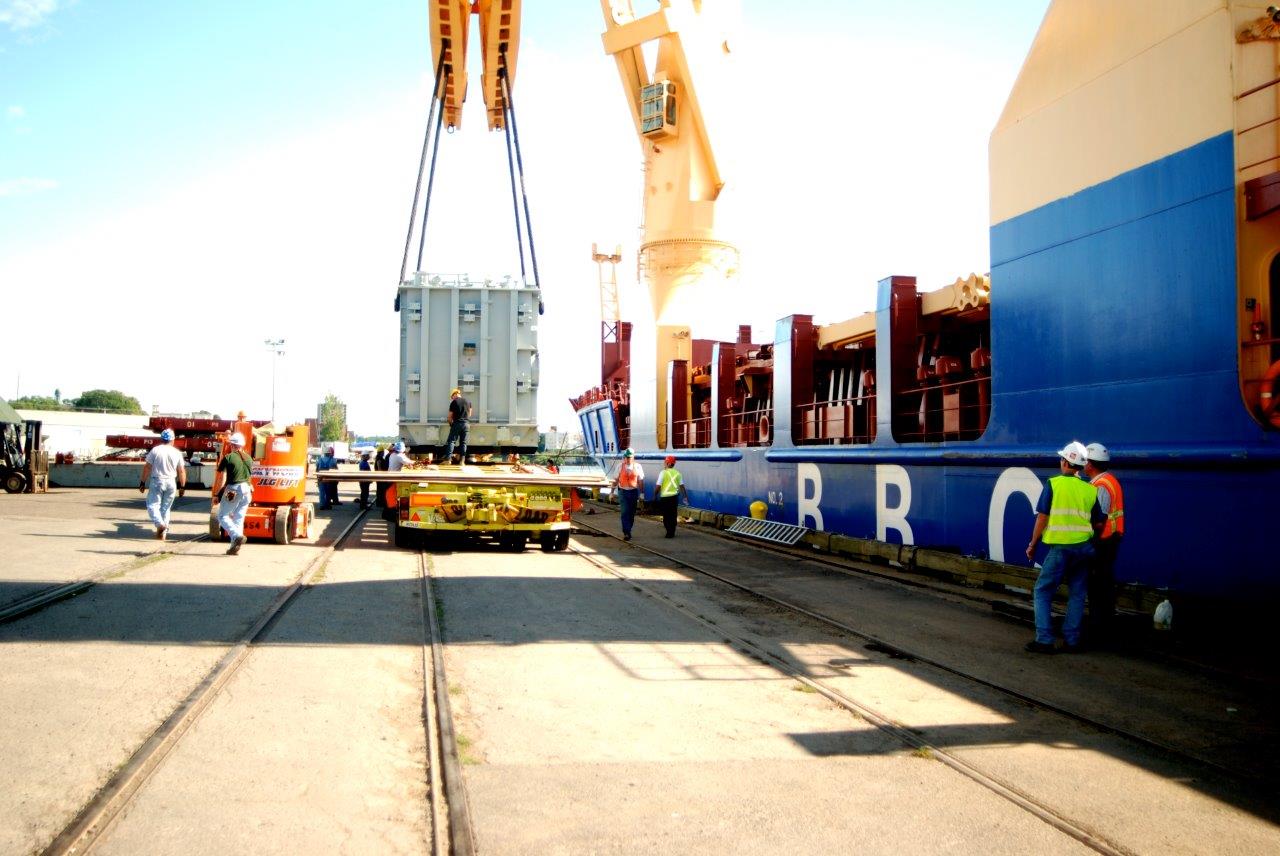 Men using crane to unload a crate from a ship at the Port of Oswego, Oswego, NY